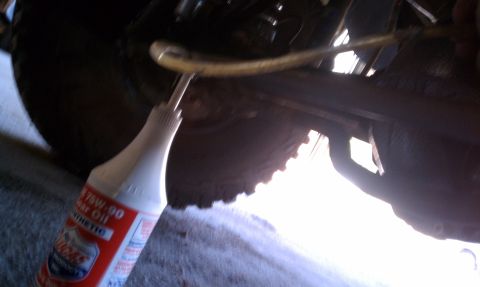 1979 Ford Bronco - A bottle of Lucas 75W-90 synthetic gear oil is used to service the differential of a vehicle.