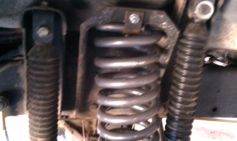 1979 Ford Bronco - Undercarriage view of a vehicle's suspension system, showing a coil spring and shock absorbers.