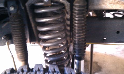 1979 Ford Bronco - The suspension system of a vehicle, showing the coil spring and shock absorber.