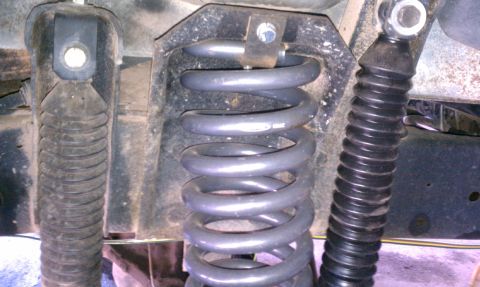 1979 Ford Bronco - The image shows the suspension components of a vehicle, including a coil spring and shock absorbers.
