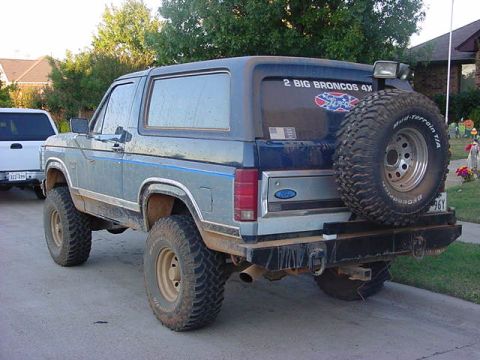 1986 Ford Bronco - This 1986 Ford Bronco is shown from the rear, a spare tire mounted on the tailgate and a "2 BIG BRONCOS 4X" sticker.