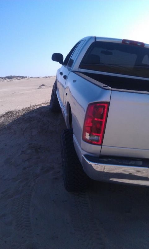 2005 Dodge 1500 - This pickup truck is parked on a sandy incline with the rear facing the camera.
