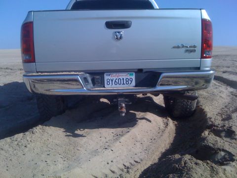 2005 Dodge 1500 - Rear view of a 2005 Dodge 1500 pickup truck driving on sand.