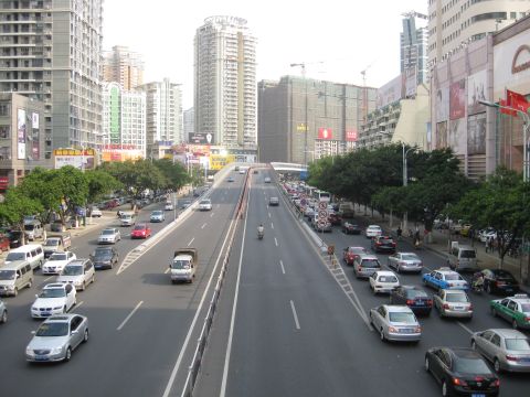 1990 Ford Probe - Vehicles are backed up on an elevated highway in a bustling city.
