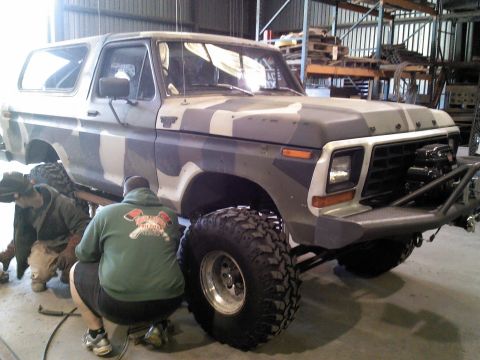 1979 Ford Bronco - A heavily modified Ford Bronco sits in a workshop, undergoing repairs or upgrades.