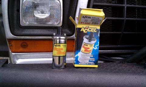 1979 Ford Bronco - An Accel Super Stock ignition coil and its packaging are displayed next to the front of a vehicle.