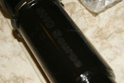 1995 Ford Taurus - Close-up of a black coilover shock absorber with embossed text.
