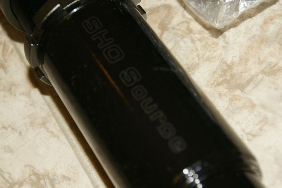Black coilover shock with 'SHO Source' embossed on it