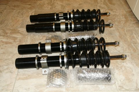 1995 Ford Taurus - Set of four coilover suspension assemblies, likely aftermarket performance parts, laid out on a tiled floor.