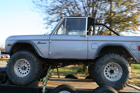 1982 Ford Bronco - Side view of a silver 1982 Ford Bronco being transported on a trailer.