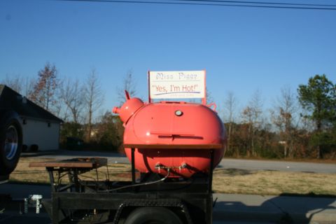 1982 Ford Bronco - This pig-shaped smoker is mounted on a trailer and has a sign that reads 'Miss Piggy, "Yes, I'm Hot!"'.