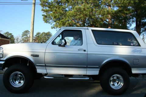 1982 Ford Bronco - This Ford Bronco SUV is shown from the side, with a driver visible inside.