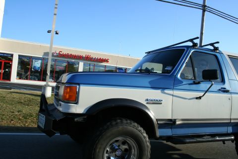1982 Ford Bronco - This Ford Bronco, likely from the late 1980s, is seen driving past a retail store.