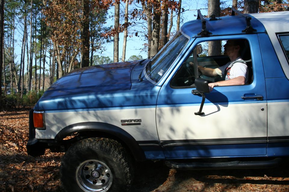 1982 Ford Bronco with blue and white paint, driver visible inside
