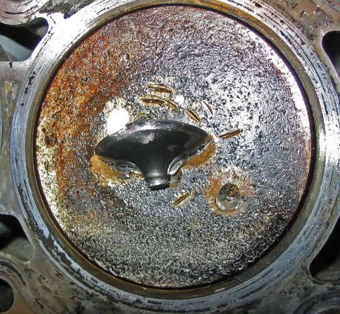 1997 Ford Taurus - Engine cylinder head shows significant corrosion and a bent valve, indicating potential internal engine damage.