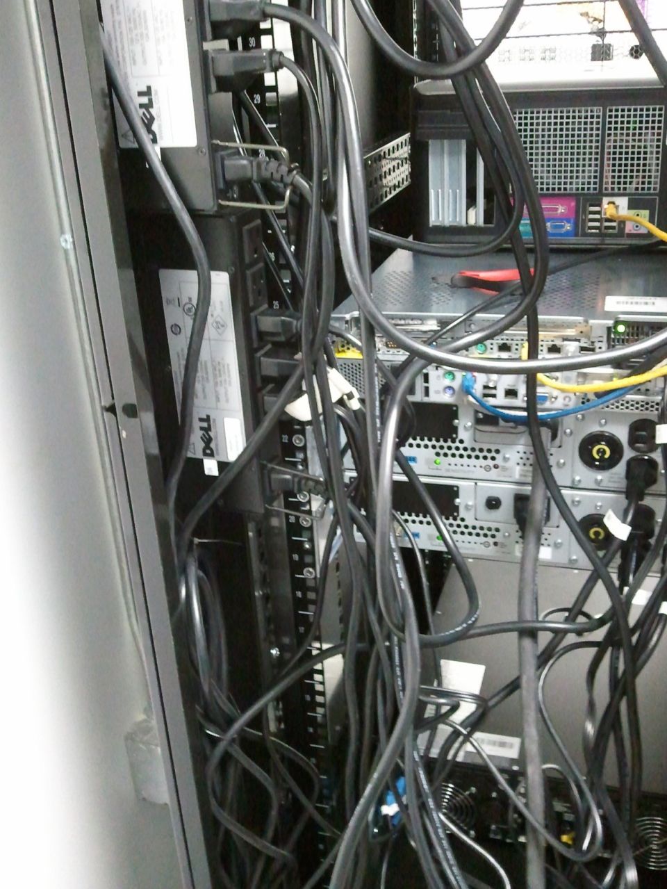 Server rack with tangled black cables and Dell power strips