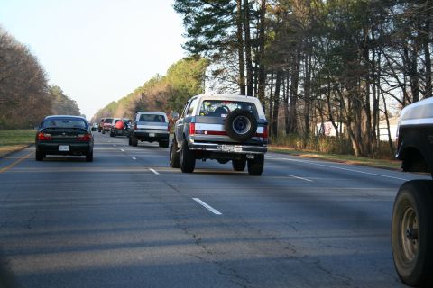 1982 Ford Bronco - A Ford Bronco is seen driving on a highway with other vehicles on a clear day.