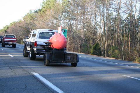 1982 Ford Bronco - A white Ford Bronco from 1987 tows a distinctive pink smoker trailer down the highway.