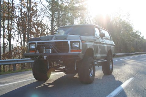 1982 Ford Bronco - This lifted Ford Bronco features a camouflage paint job and an aftermarket front bumper with a winch.