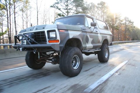 1982 Ford Bronco - This heavily modified Ford Bronco features a camouflage paint scheme and an aggressive front brush guard.
