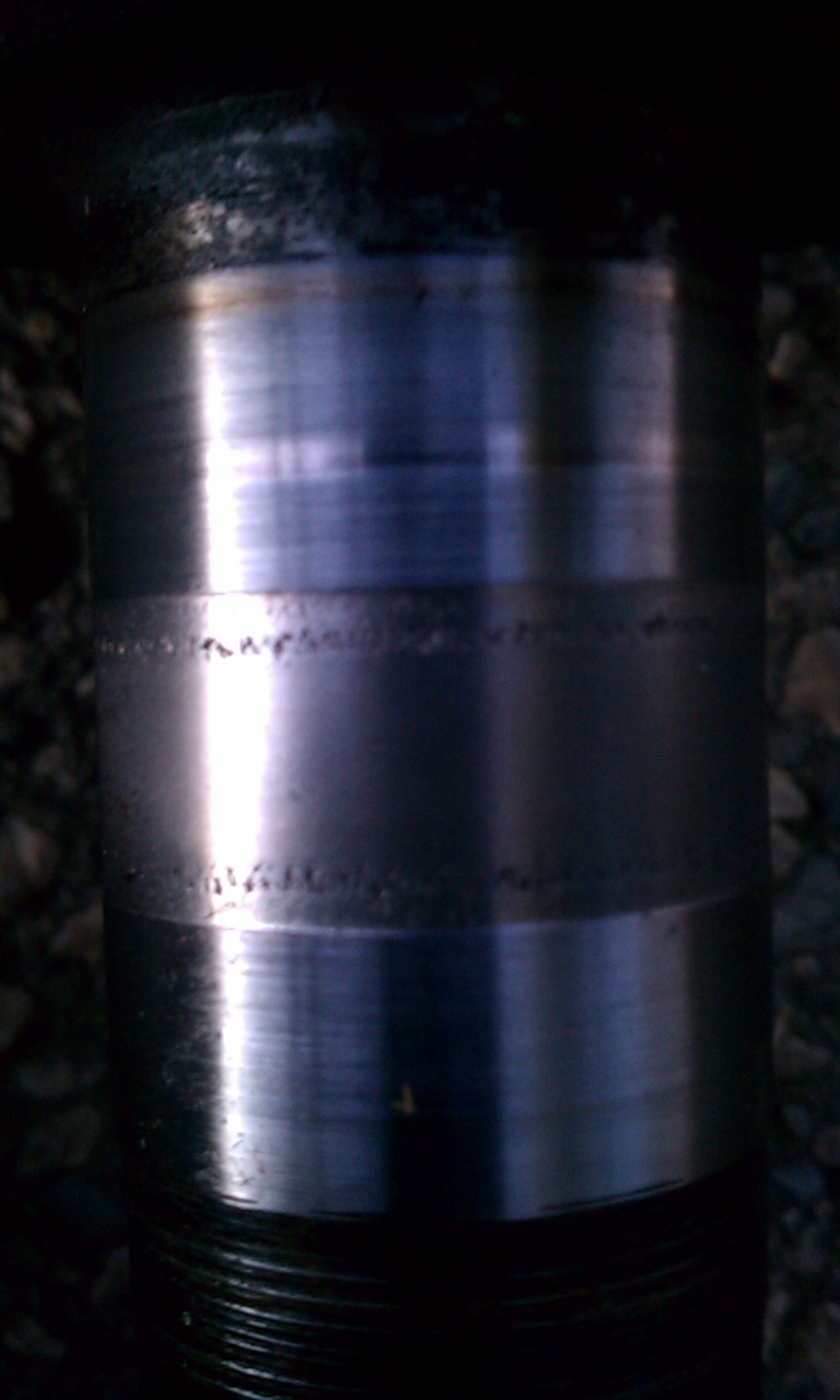 Close-up of a worn metal differential part with visible scoring and pitting