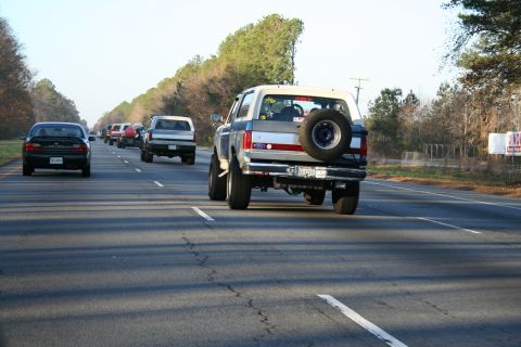 1982 Ford Bronco - A 1982 Ford Bronco travels down the highway, seen from behind with other cars on the road.