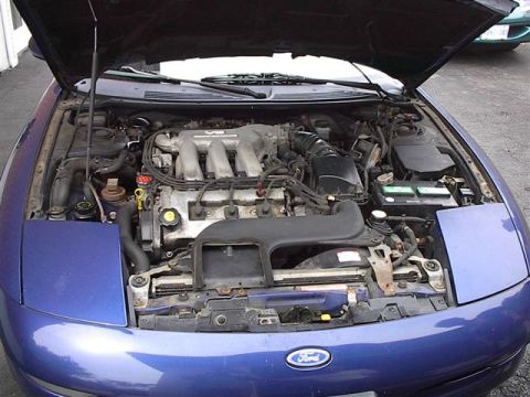 1993 Ford Probe - The engine bay of a blue 1993 Ford Probe is shown with the hood raised.
