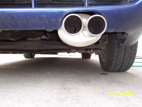 1993 Ford Probe - Underside view of a blue car's dual exhaust system and rear tire.