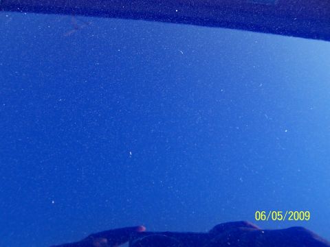 1993 Ford Probe - Close-up of a dusty blue car hood, showing surface imperfections and a watermark.
