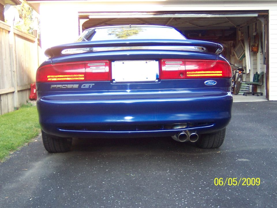 Blue Ford Probe GT rear view with dual exhaust tips and spoiler in a driveway