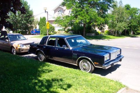 1986 Chrysler Fifth Avenue - A 1986 Chrysler Fifth Avenue is parked on the street next to another car.