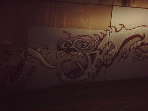 1996 Ford Bronco - A mural of a dragon is painted on a wall, with a website address visible at the bottom.