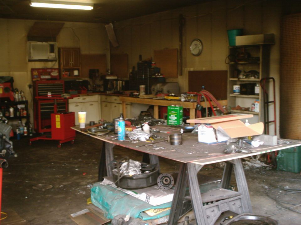 Messy garage interior with tools and parts on a workbench