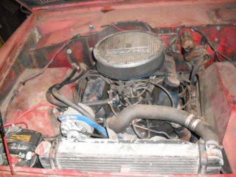 1968 Ford Bronco - The engine bay of a vehicle shows the V8 engine, air cleaner, radiator, and battery.