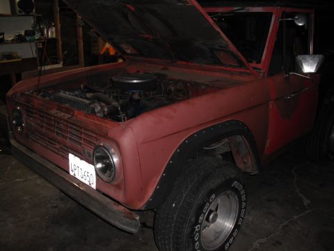 1968 Ford Bronco - A red 1968 Ford Bronco is shown with its hood open, revealing the engine and front end.
