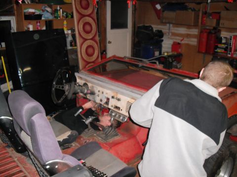 1968 Ford Bronco - A person works on the dashboard of a 1968 Ford Bronco in a garage setting.