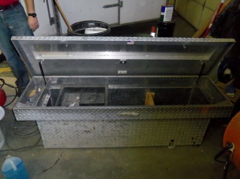 2000 Mercury Grand Marquis - An open aluminum truck bed tool box sits on the floor, revealing its internal compartments and diamond plate exterior.