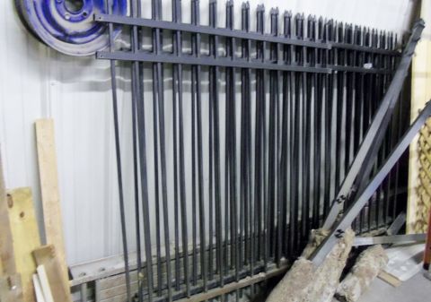 2000 Mercury Grand Marquis - Wrought iron fence panels are stored indoors, with a blue wheel rim in the background.