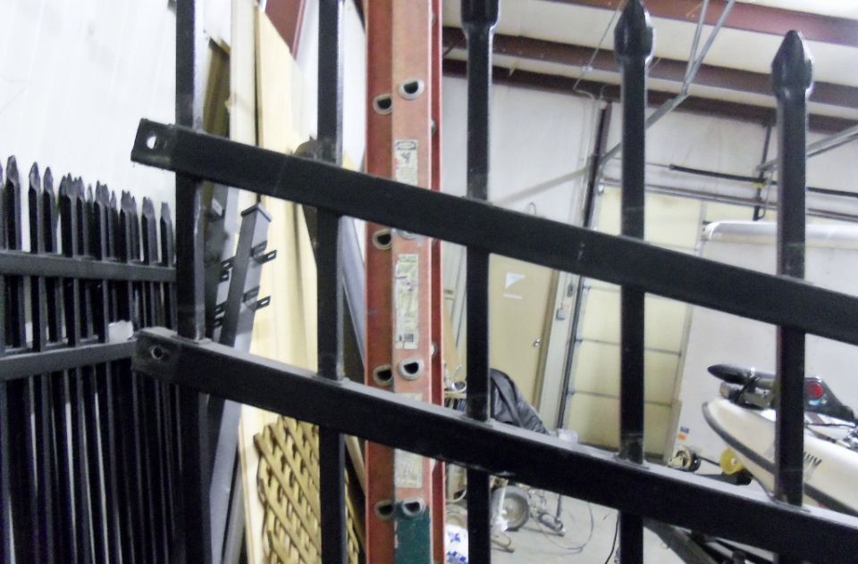 Jet ski partially visible behind a black metal fence, with a ladder and garage door in the background