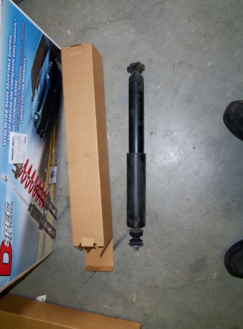 2000 Mercury Grand Marquis - A single shock absorber and its packaging are displayed on a concrete floor.