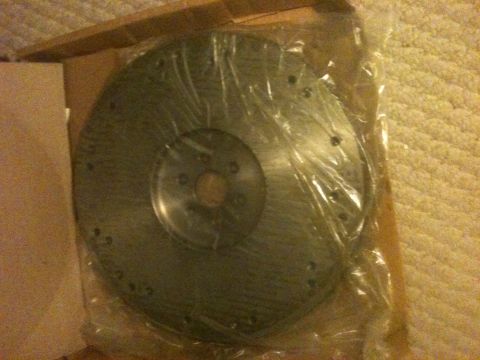 1993 Ford Bronco - A new brake rotor is shown packaged for sale, sitting on a carpeted surface.