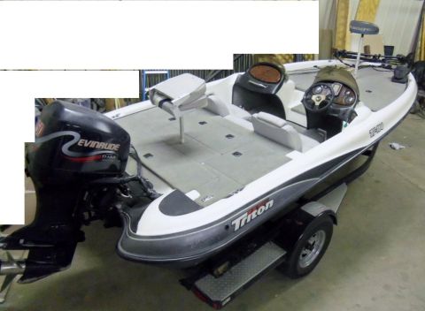 2000 Mercury Grand Marquis - A white and gray bass boat with an Evinrude outboard motor is parked on a trailer.