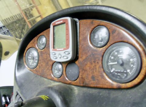 2000 Mercury Grand Marquis - The dashboard of a boat features several gauges and a mounted GPS unit, with a wood-grain accent panel.