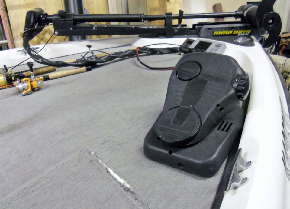 Boat deck with trolling motor, fishing rods, and control pedal