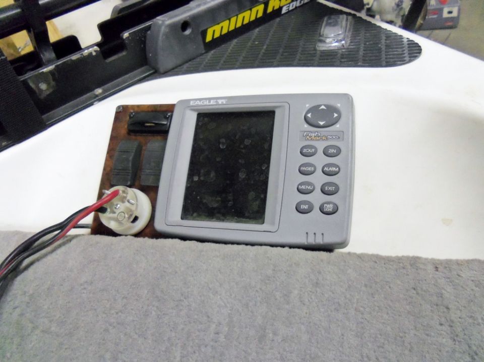 Eagle fish finder unit with buttons and wiring, next to a Minn Kota trolling motor mount