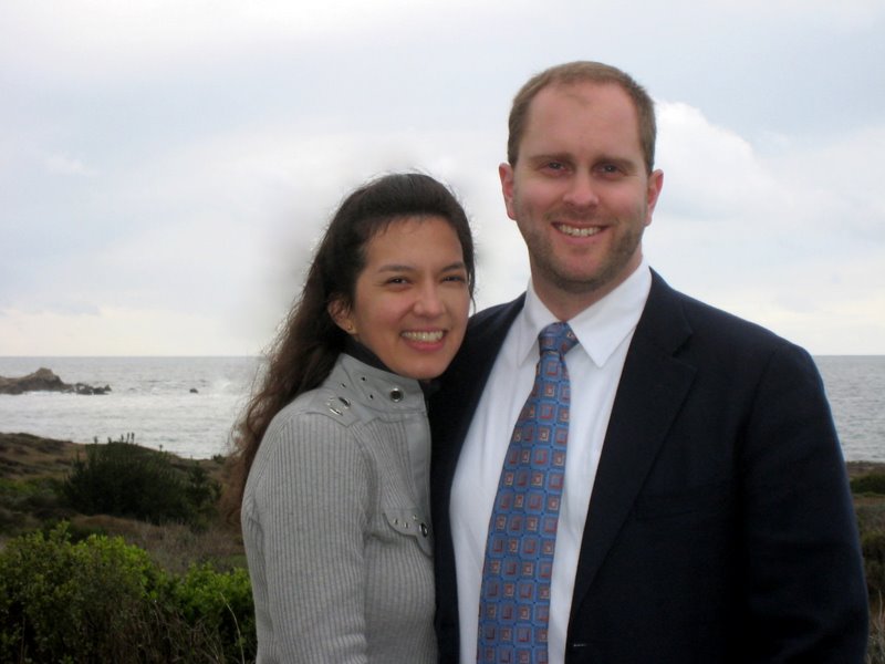 Couple posing by the ocean with a watermark