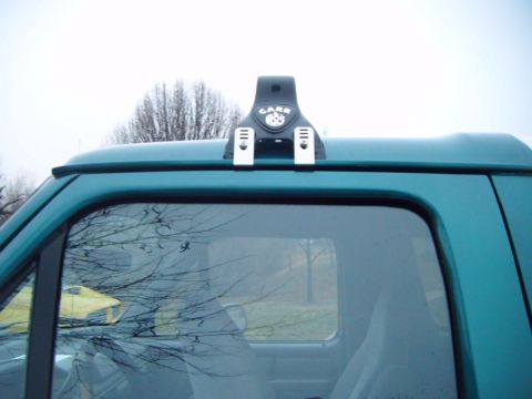 1996 Ford Bronco - A close-up view of a CARR light mount attached to the roof of a teal-colored SUV.