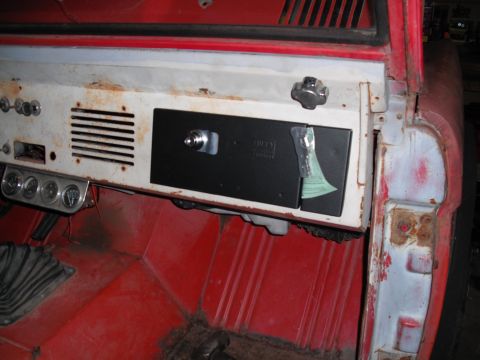 1968 Ford Bronco - Stripped interior of an early Bronco shot from the passenger side, showing the rusty white painted dash with its defroster vents, a black a…