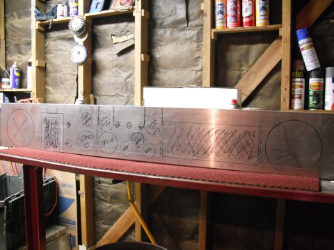 1968 Ford Bronco - A bare sheet-aluminum custom dash panel laid on a shop bench, marked out in black marker with hand-drawn circles and labels including SPEED…