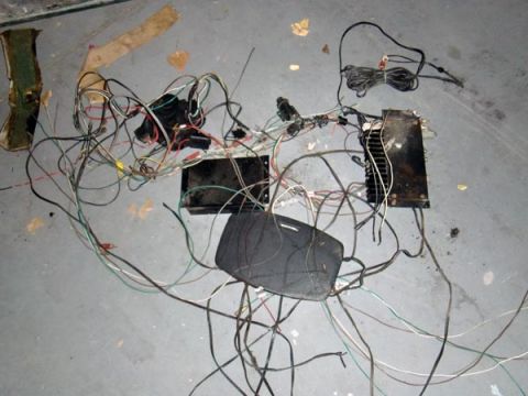 1969 Volvo P1800 - A tangled mess of wires and electronic parts, likely from a car's electrical system, lies scattered on the floor.